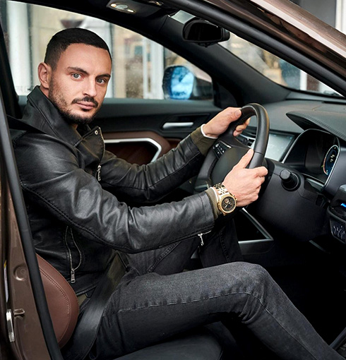 A right close up of a yellow Mercedes AMG sports car headlight on a city street