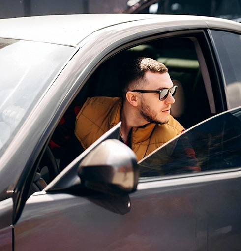 A right close up of a yellow Mercedes AMG sports car headlight on a city street