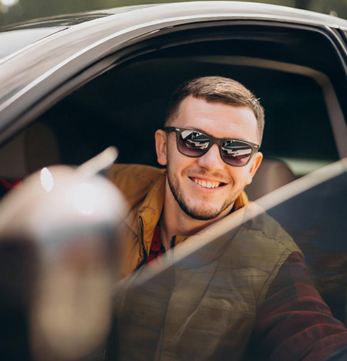 A right close up of a yellow Mercedes AMG sports car headlight on a city street
